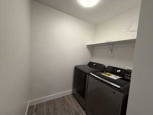 Laundry room featuring dark wood finished floors and independent washer and dryer