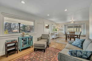 Living area with plenty of natural light, wood finished floors, and recessed lighting