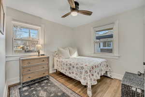 Bedroom featuring wood finished floors, ceiling fan, and multiple windows