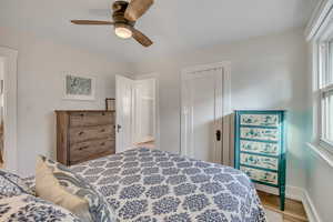 Bedroom with a closet, ceiling fan, and light wood-style floors