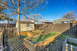 Fenced backyard featuring a garden