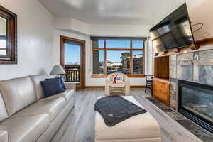 Living area with wood finished floors and a tiled fireplace