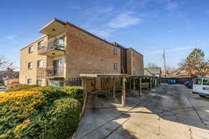 View of apartment building / complex with covered parking