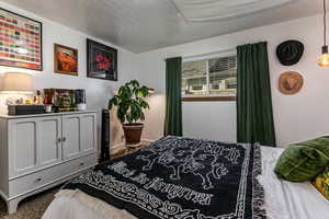 Carpeted bedroom with a textured ceiling