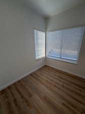 Spare room featuring baseboards and wood finished floors