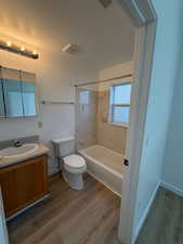 Bathroom featuring vanity, washtub / shower combination, and light wood-type flooring