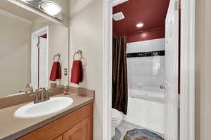 Bathroom with shower / bath combo, vanity, and light tile patterned flooring
