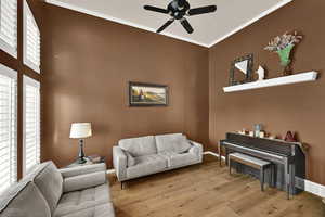 Living area featuring ornamental molding, hardwood / wood-style floors, and a ceiling fan