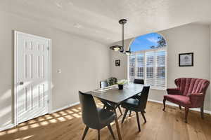 Dining space featuring light wood-type flooring and a textured ceiling