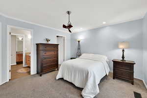 Bedroom with crown molding, light carpet, recessed lighting, and connected bathroom