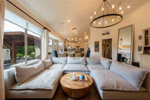 Living area featuring a chandelier, recessed lighting, and high vaulted ceiling