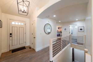 Entryway with dark wood finished floors, a chandelier, and recessed lighting