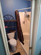 Bathroom with a shower stall and toilet