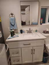 Bathroom with vanity and washer / dryer