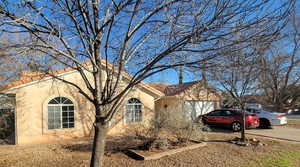 View of front facade featuring stucco siding, driveway, a garage, and a tiled roof