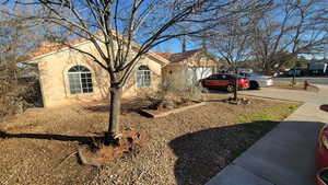 View of home's exterior featuring stucco siding, driveway, a garage, and a tiled roof