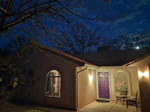 Property exterior at night with stucco siding and a chimney