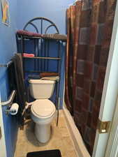 Full bathroom with a shower with curtain and toilet