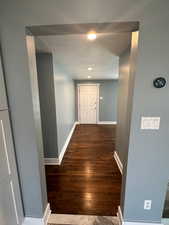 Corridor featuring baseboards and dark wood finished floors