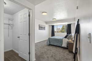 Bedroom featuring a textured ceiling and dark colored carpet
