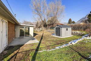 View of yard featuring a shed and a patio