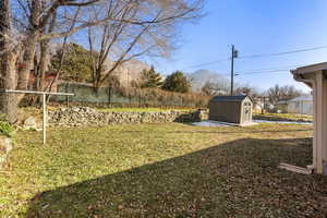 View of yard with a storage shed and amazing mountain views