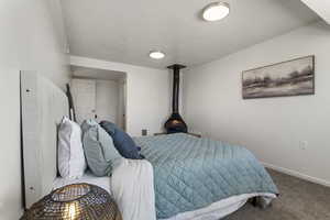 Carpeted bedroom featuring baseboards and a textured ceiling