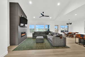 Living area with a fireplace, light wood finished floors, recessed lighting, and a ceiling fan