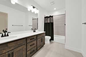 Bathroom with shower / bath combination with curtain, double vanity, and light tile patterned floors