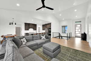Living area with light wood-style floors, vaulted ceiling, ceiling fan, and recessed lighting