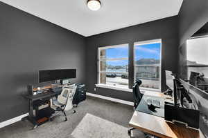 Office/bedroom space with light colored carpet and baseboards