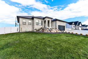 View of front of home with stone siding and a garage