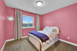 Bedroom with a textured ceiling and carpet flooring