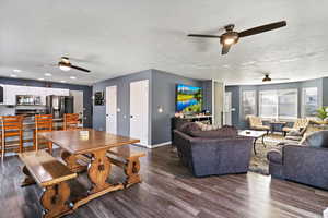 Dining room with ceiling fan and dark wood-style flooring