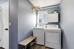 Laundry area featuring dark wood-style floors and washer and clothes dryer