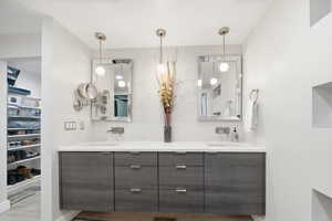 Full bath featuring double vanity, a walk in closet, and tasteful backsplash