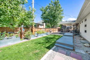 Fenced backyard with a patio, a garden, and a deck