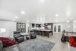 Living room with french doors, recessed lighting, and light wood finished floors