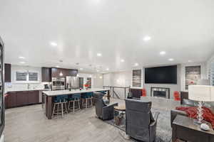 Living area featuring a glass covered fireplace, wood tiled floors, and recessed lighting