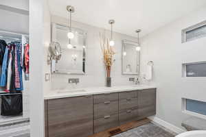 Full bath with double vanity and a spacious closet