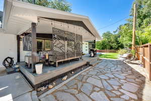 Fenced backyard featuring a deck and a patio