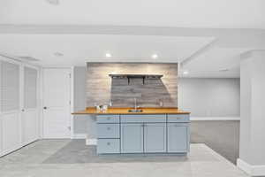 Indoor wet bar with wood counters, recessed lighting, an accent wall, wooden walls, and light colored carpet