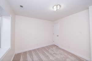 Carpeted spare room with baseboards