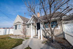 View of front of home featuring roof with shingles and a chimney