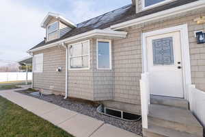 Property entrance featuring a shingled roof