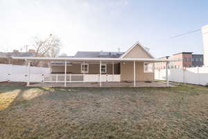 Rear view of house featuring a fenced backyard, a gate, and a patio area