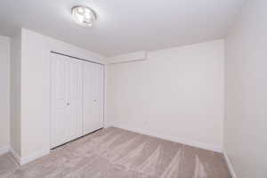 Unfurnished bedroom featuring light carpet and a closet