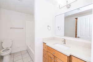 Full bathroom featuring vanity, light tile patterned floors, and bathtub / shower combination