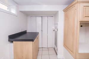 Kitchen featuring dark countertops, light tile patterned floors, and light brown cabinetry