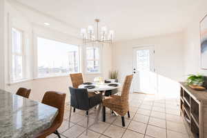 Dining area with light tile patterned floors and a chandelier